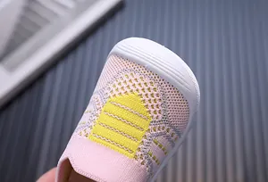 Dettaglio macro della maglia traspirante rosa e della suola bianca morbida per scarpe neonato