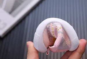 Dettaglio della suola morbida e flessibile delle scarpe da passeggio rosa flyknit per neonati