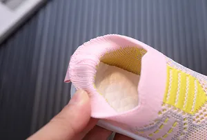 Vista macro della scarpa da neonato in maglia rosa con apertura elastica molto morbida