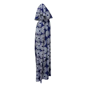 Detalle de perfil de un vestido largo con estampado geométrico azul y blanco y volantes.