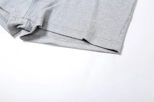 Primo piano del tessuto a costine grigio e delle cuciture sull'orlo degli shorts da donna