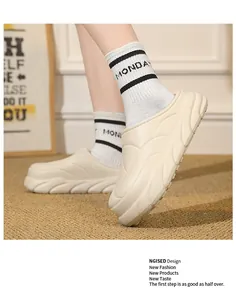 Close-up of warm beige platform clogs with stylish wavy texture worn with socks.