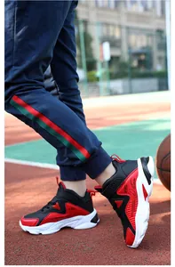 Détail de baskets de basket-ball en cuir imperméables noir et rouge pour garçons en plein air.