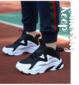 Gros plan détaillé de baskets imperméables noir et blanc pour garçons sur piste de sport.