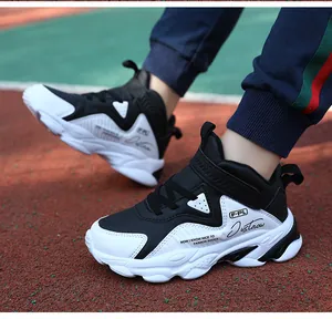 Vue détaillée des baskets de sport imperméables noir et blanc pour garçons sur une piste