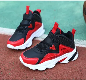 Vue détaillée des chaussures de basket montantes rouge et noir pour garçons sur piste