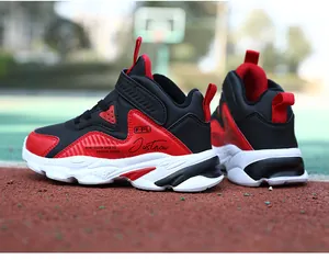 Vue latérale de baskets de basket imperméables noires et rouges pour garçons.