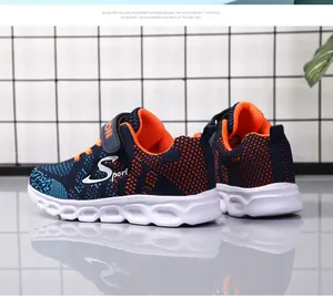 Dettaglio di scarpe da ginnastica traspiranti blu e arancioni per bambini con suola bianca