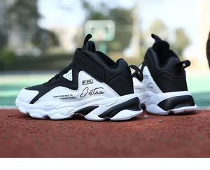 Vue latérale des chaussures de basket en cuir imperméable pour garçons, noir et blanc
