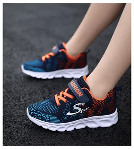 Dettaglio delle sneakers traspiranti in maglia da bambino su uno sfondo di asfalto scuro.