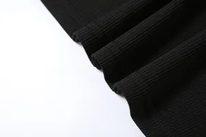 Dettaglio del tessuto a maglia a coste nere e delle cuciture dell'orlo del set casual