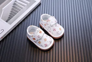 Primo piano di scarpe per neonati con orsetti su sfondo strutturato