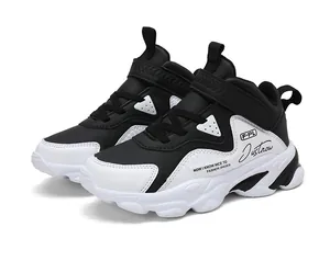 Baskets de sport noires et blanches pour garçons avec bandes auto-agrippantes.