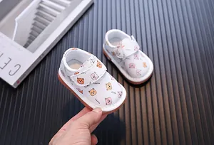 Vista ravvicinata dei simpatici orsetti sulle scarpe primi passi bianche per neonati