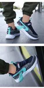 Detailed close-up of boys' breathable fly-knit sports sneakers with teal accents and wavy sole