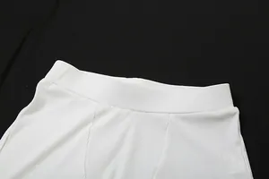 Dettaglio ravvicinato di pantaloncini bianchi a vita alta a costine con elastico in vita comodo.