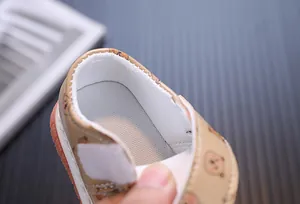 Primo piano della morbida fodera in rete e del motivo a orsetto di queste scarpe da bimbo.