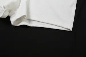 Dettaglio macro dell'orlo a coste bianco che mostra la qualità della doppia cucitura