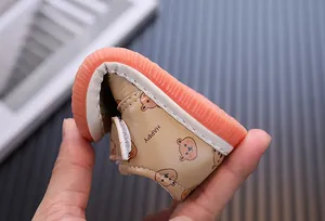 Primo piano della scarpa da passeggio flessibile in cartone per neonati beige e arancione