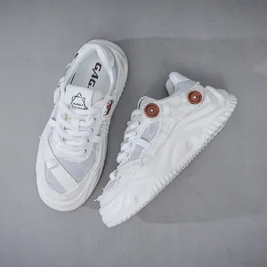 Λεπτομερής όψη των λευκών sneakers με χοντρή σόλα και διακοσμητικά κουμπιά σε μοντέρνο σχέδιο
