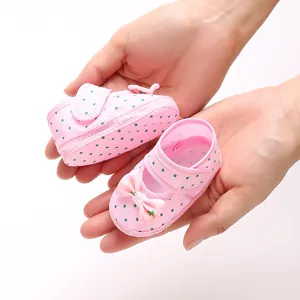 Close-up detail of pink polka dot baby girl princess shoes with a decorative bow