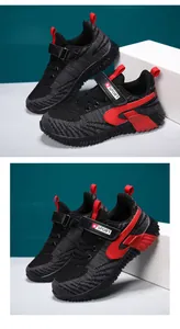 Detailed view of boys' breathable fly-knit sneakers with red accents and velcro strap.