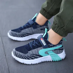 Breathable fly-knit boys' sports sneakers in navy and teal on a child's feet, lightweight