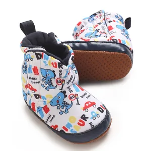 Nahaufnahme von Baby-Schneestiefeln mit Dino-Motiv und weichen Antirutschsohlen.