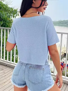Achteraanzicht van een vrouw met een blauwe wafelgebreide top en denim shorts