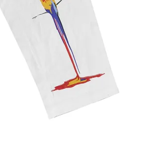 Gros plan détaillé de l'imprimé perroquet coloré sur un pantalon en lin et coton blanc