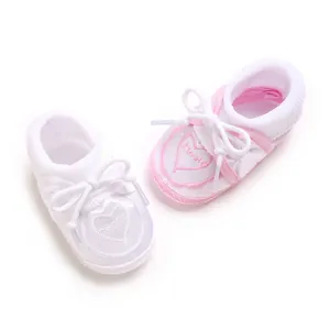 Vue détaillée de chaussettes bébé antidérapantes avec broderie cœur et nœuds