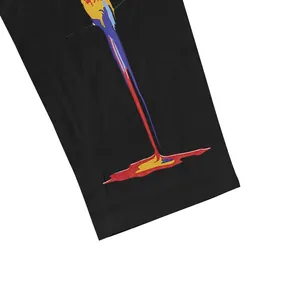 Détail de l'imprimé perroquet sur un pantalon décontracté noir en coton et lin.