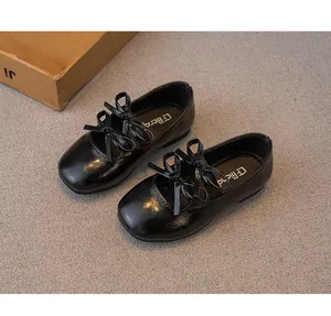 Detailansicht schwarzer Lackleder-Ballerinas für Mädchen mit Schleifendekoration.