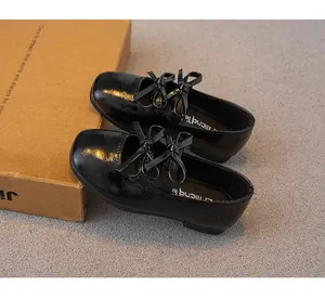 Detail von schwarzen Lackleder-Prinzessinenschuhen für Mädchen mit eleganter Schleife