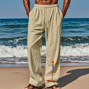 Détail d'un pantalon en lin pour homme avec un imprimé perroquet sur la jambe à la plage.