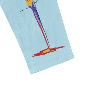 Gros plan sur l'imprimé perroquet vibrant d'un pantalon en coton et lin bleu.