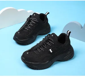 Primer plano de zapatillas chunky de malla transpirable negra para niños con cordones moteados.