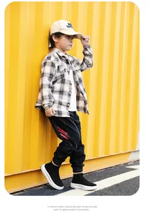 Chaussures chaussettes en tricot noir élégantes portées par un enfant sur un fond jaune