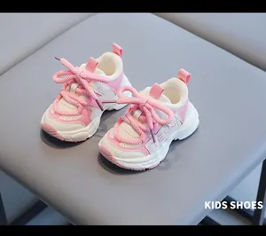 Close-up of pink and white toddler sneakers with thick soft soles on gray background