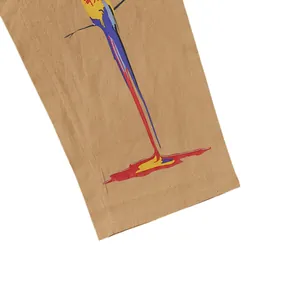 Gros plan de l'imprimé perroquet coloré sur un pantalon décontracté en coton et lin.