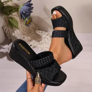 Detail view of black wedge sandals featuring a stylish woven strap and leopard print band.