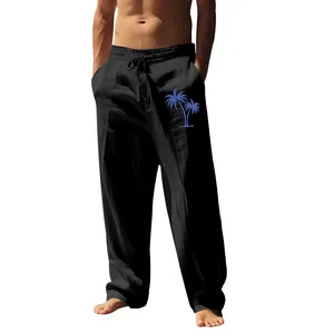 Detail of men's loose black cotton linen pants featuring a blue palm tree print.