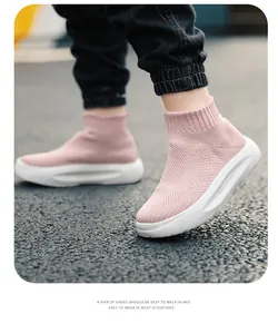 Gros plan de baskets montantes roses en maille respirante pour enfants portées dehors