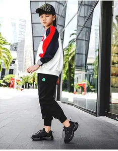 Primer plano de zapatillas chunky negras de malla transpirable para niño en entorno urbano