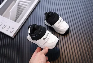 Close-up of black and white waterproof leather toddler sneakers with velcro straps