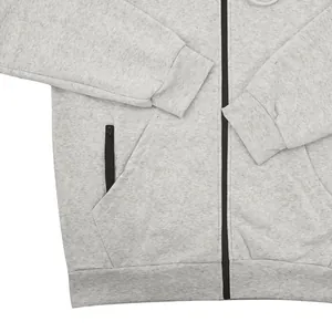 Détail d'un sweat à capuche gris pour hommes avec poches zippées et bords-côtes.