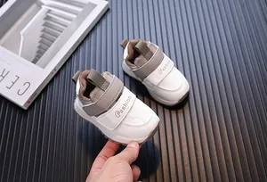 Close-up detail shot of white and grey leather waterproof toddler walking shoes
