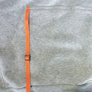 Close-up detail of a gray casual hoodie showing the orange adjustable strap on the pocket.