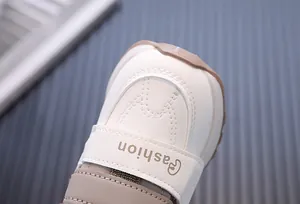 Detail view of baby walking shoe showing soft white leather toe and fashion velcro strap
