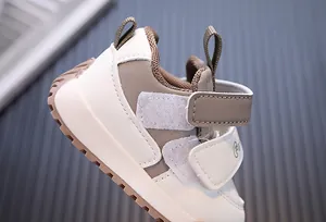 Detailed view of beige and brown waterproof leather toddler sneakers with velcro straps